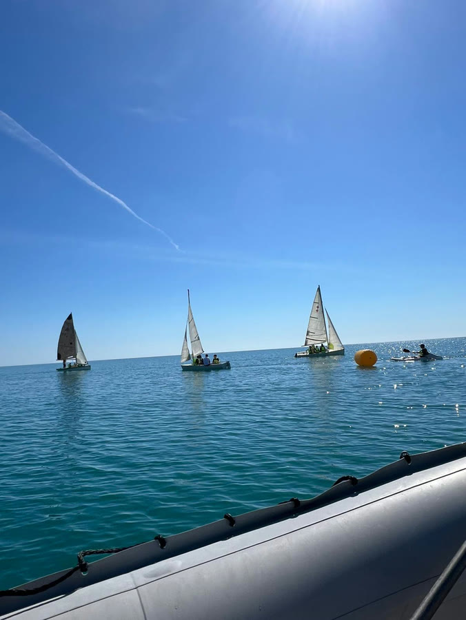 Le derive a vela in mare, viste dal gommone di assistenza